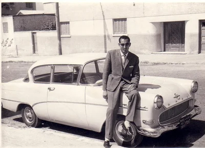 A member of the ElBishbishy family standing beside a car outside the farmhouse
